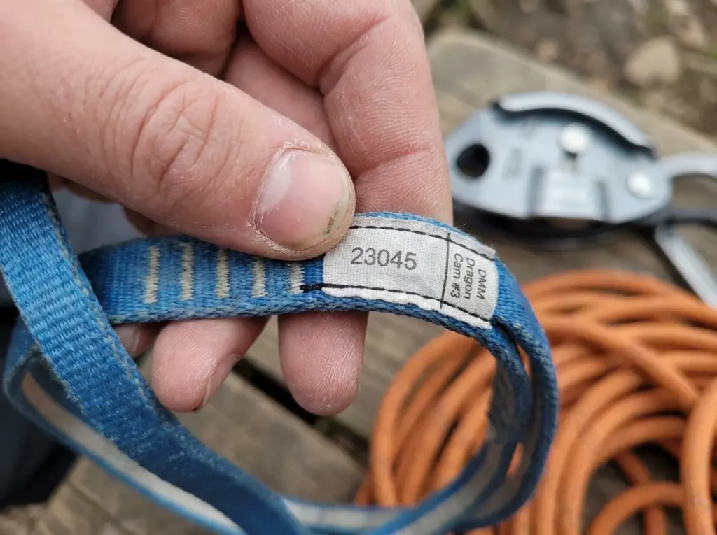 Close up of manufacturer date code label on used climbing cam sling for age verification