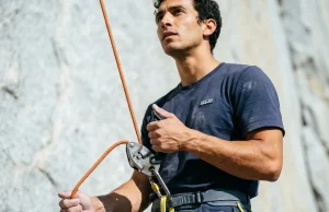 7 Common Belay Mistakes That Cause Accidents Outdoors Climber belaying with a Petzl GriGri, brake hand locked below the device on a granite sport crag
