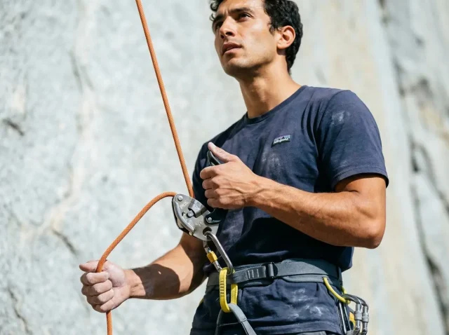 common-belay-mistakes-cause-accidents-outdoors Climber belaying with a Petzl GriGri, brake hand locked below the device on a granite sport crag