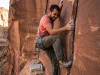 How to Crack Climb for Beginners the Right Way Beginner climber on splitter hand crack in red sandstone canyon, learning crack climbing basics
