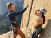 Hiring a Local Climbing Guide: What to Ask and What to Pay Certified climbing guide pointing out the next pitch to a client on a granite multi-pitch route