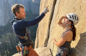 Hiring a Local Climbing Guide: What to Ask and What to Pay Certified climbing guide pointing out the next pitch to a client on a granite multi-pitch route