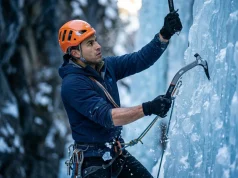 8-Week Ice Climbing Fitness Training Plan Field-Tested Ice climber executing precise wrist-driven Petzl Nomic swing on a steep WI4 blue ice pillar