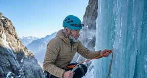 4 V-Thread Mistakes That Get Climbers Hurt Ice climber threading cord through blue ice V-thread anchor at alpine waterfall in winter