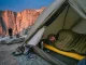 Why Sleep Is the Climbing Training You Skip Most Climber sleeping in tent at base of granite crag with climbing gear laid out beside them
