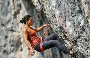 How to Practice Falling in Sport Climbing the Right Way Climber practicing a controlled lead fall on overhanging limestone sport route with Petzl harness