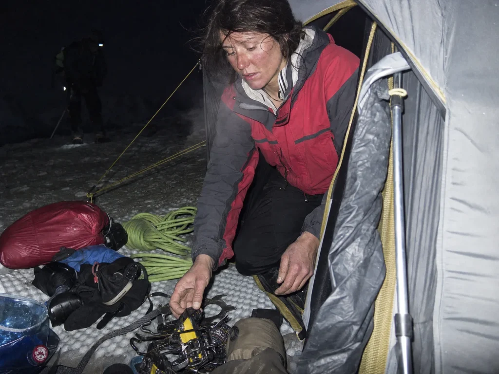 Climber sorting gear at high camp at dusk during acclimatization on Huascaran — Huascaran acclimatization