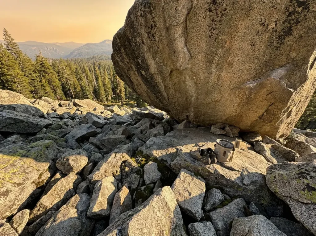 Rocky talus landing zone below granite boulder with no crash pads visible