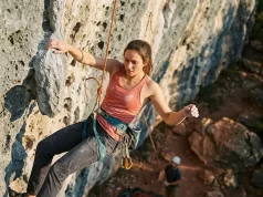 5 Hangdogging Mistakes That Waste Your Crag Day Climber resting on rope while hangdogging a steep sport route outdoors