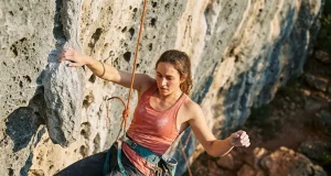 5 Hangdogging Mistakes That Waste Your Crag Day Climber resting on rope while hangdogging a steep sport route outdoors
