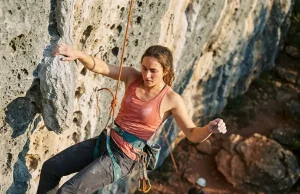 5 Hangdogging Mistakes That Waste Your Crag Day Climber resting on rope while hangdogging a steep sport route outdoors