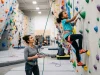 Why Most Kids Quit Climbing (And How to Prevent It) Young child climbing colorful indoor wall with parent belaying below