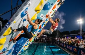 How Psicobloc Competitions Actually Work Two climbers racing side by side on overhanging psicobloc wall above deep pool