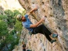 Why Rifle Routes Feel Two Grades Harder Than They Are Sport climber clipping quickdraw on overhanging limestone at Rifle Mountain Park Colorado