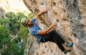 Why Rifle Routes Feel Two Grades Harder Than They Are Sport climber clipping quickdraw on overhanging limestone at Rifle Mountain Park Colorado