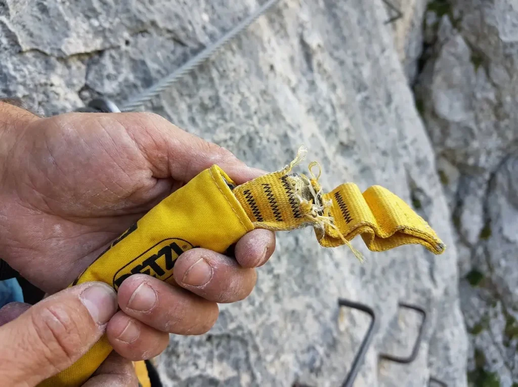 Cross section view of via ferrata energy absorber with accordion-folded webbing
