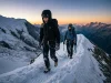 How Alpinism Actually Works on the Mountain Two alpinists moving together on a glaciated ridge at dawn, French Alps, crampons and ice axes
