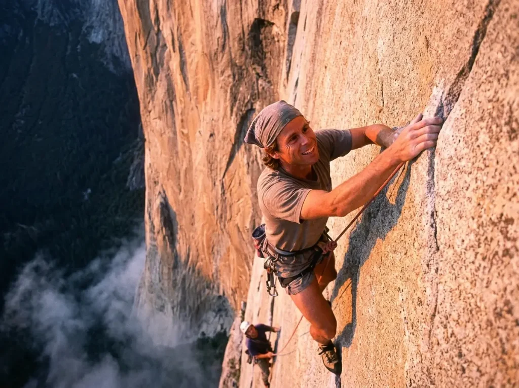 Two climbers moving fast and light at dawn on a vast El Capitan granite wall, simul-climbing