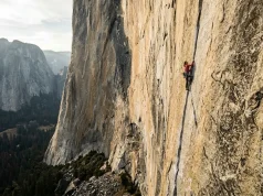 13 Legendary American Climbers Who Shaped the Sport Climber high on a vast El Capitan granite wall at golden hour, the canon of legendary American climbers