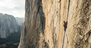 13 Legendary American Climbers Who Shaped the Sport Climber high on a vast El Capitan granite wall at golden hour, the canon of legendary American climbers