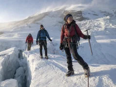 4 Mount Rainier Routes and Who Each One Is For Roped climbing team crossing a glacier on Mount Rainier at first light