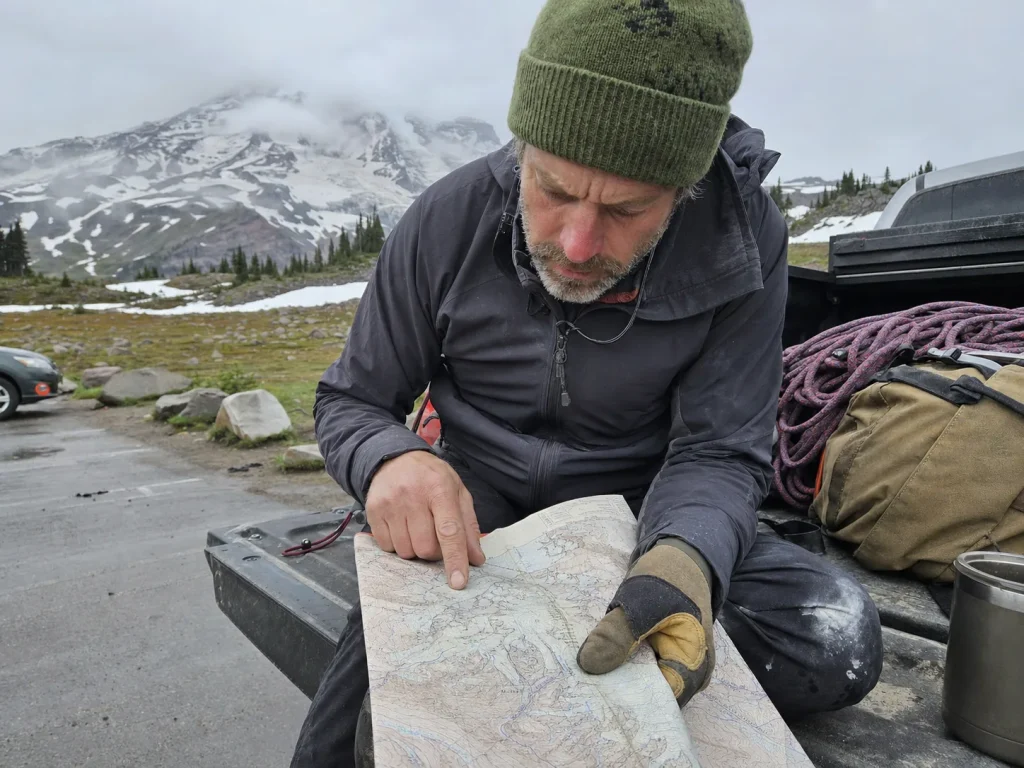 Climber studying a Mount Rainier route map at the Paradise trailhead