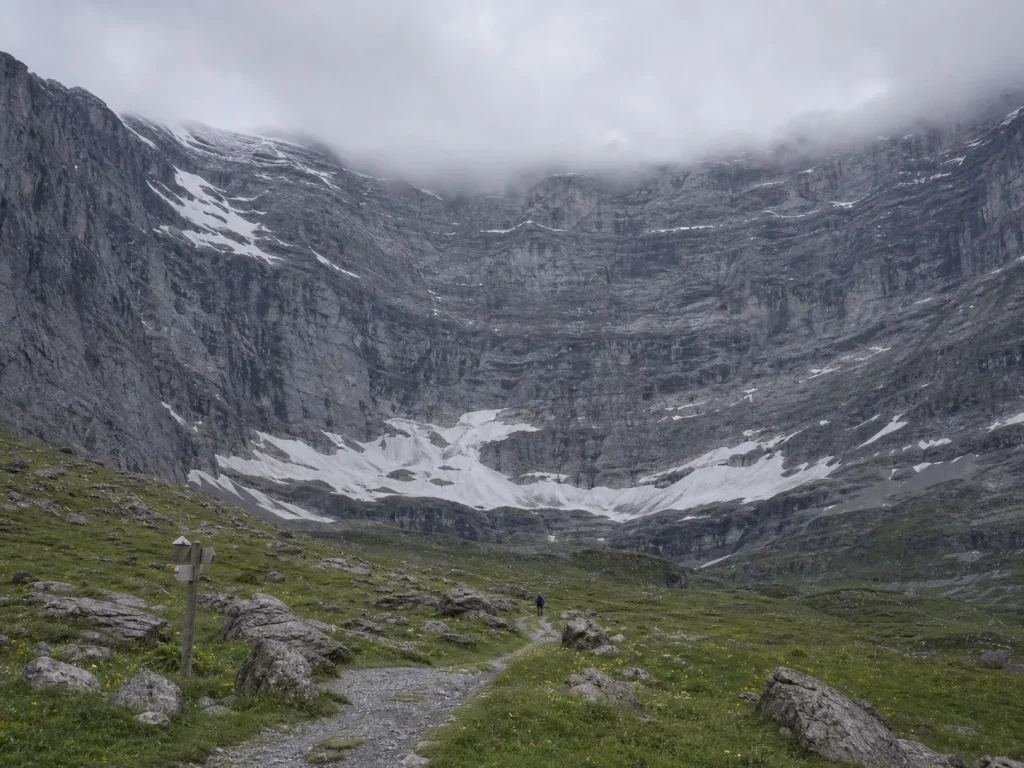 Full north face of the Eiger rising above green meadows near Kleine Scheidegg