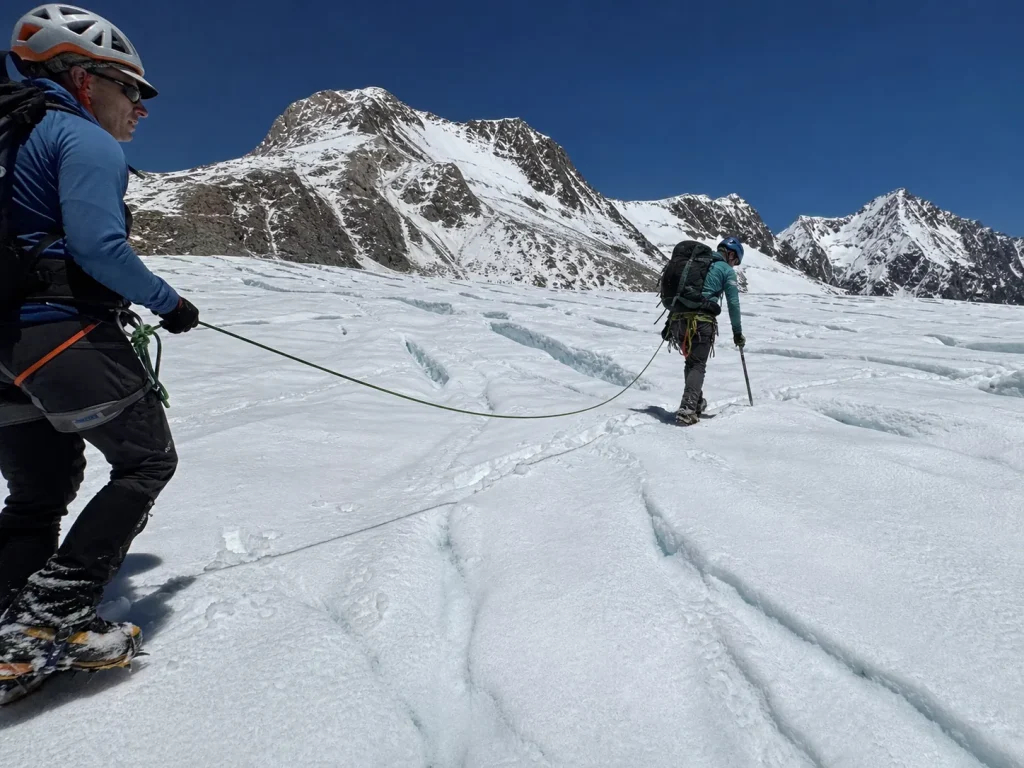 Roped climbers practicing glacier travel on a lower training peak