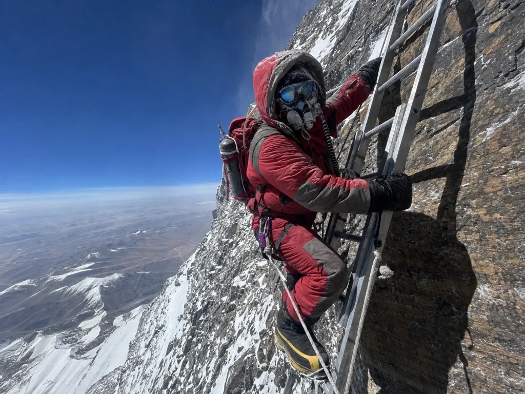 Mountaineer on the fixed ladder of the Second Step on Everest's North Ridge route