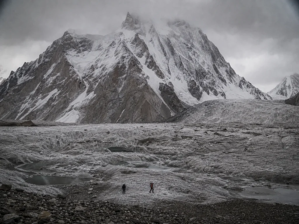 Two small climbers crossing a remote glacier on K2's Chinese north side