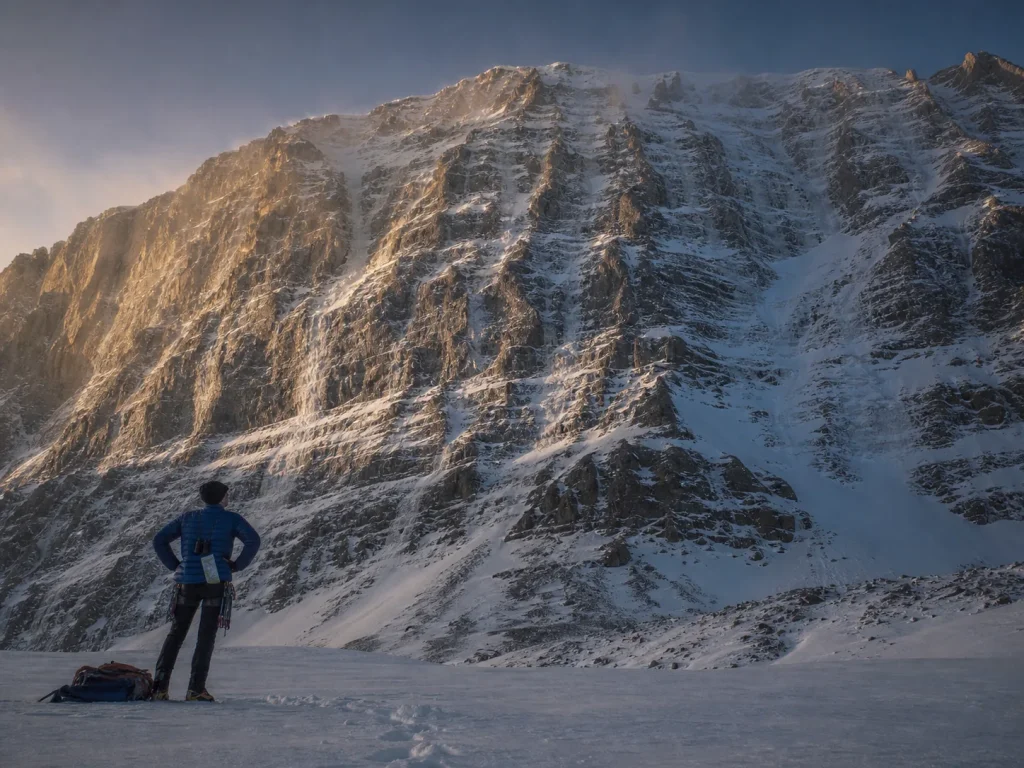 Climber studying the many possible lines up the full Eiger North Face at dusk