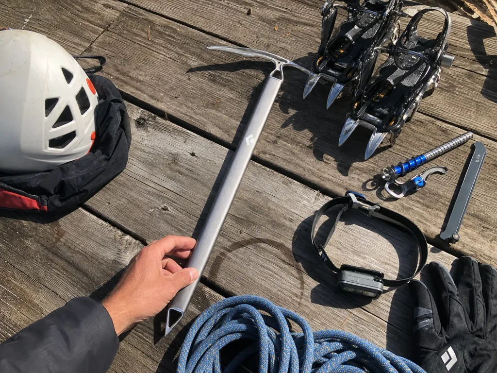 Climber's mountaineering kit laid out with a Black Diamond Raven ice axe before a Rainier climb