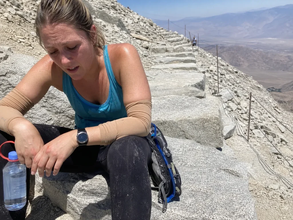 Exhausted hiker resting on the 99 switchbacks below Trail Crest on Mount Whitney