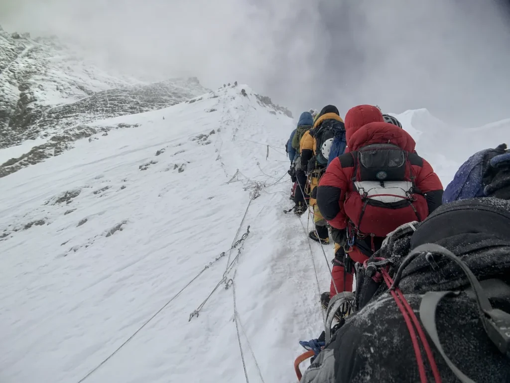 A line of climbers queued and waiting on fixed ropes high on K2