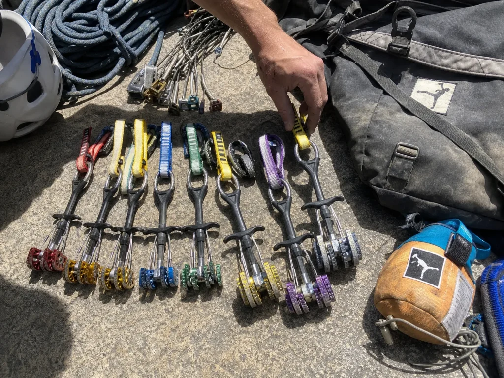 Big wall rack of Black Diamond Camalot cams and a Metolius haul bag laid out at El Capitan base
