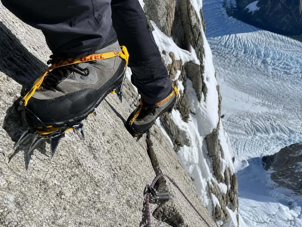 Climber's Grivel G12 crampons edging on bare granite below rime ice on Cerro Torre's Southeast Ridge