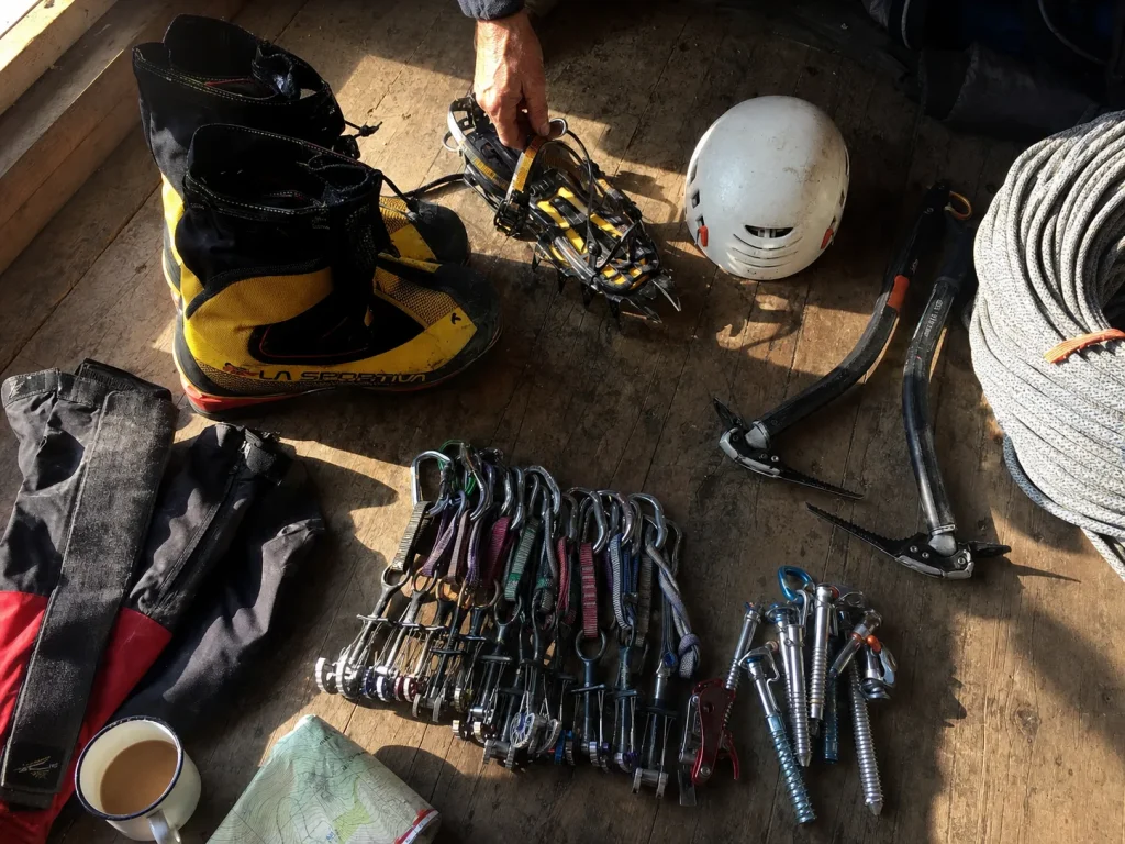 Alpine kit sorted on a hut floor before an Eiger attempt with boots and crampons
