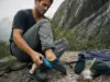 Best Climbing Shoes for Wide Feet 9 Lasts Compared Climber checking the fit of climbing shoes for wide feet before pulling on at a granite crag