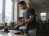 How to Clean Climbing Shoes Without Cooking the Glue Climber cleaning climbing shoes by hand at a kitchen sink after a session